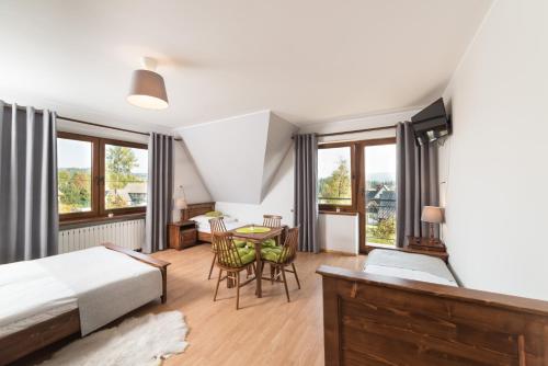 a bedroom with a bed and a table and chairs at Szyszka in Bukowina Tatrzańska