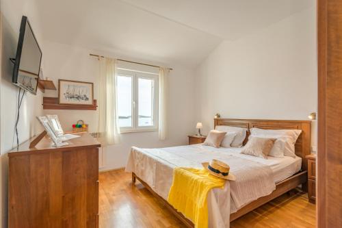 ein Schlafzimmer mit einem Bett mit einer gelben Decke darauf in der Unterkunft Ivkolina in Hvar