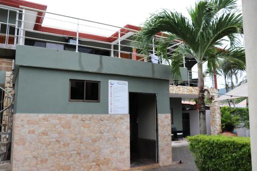 a building with a palm tree in front of it at 11B Jaco Sol Quadplex in Jacó