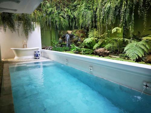 a bathroom with a tropical garden and a swimming pool at The Inside House in Chiang Mai