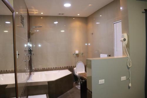 a bathroom with a shower and a tub and a toilet at 11B Jaco Sol Quadplex in Jacó