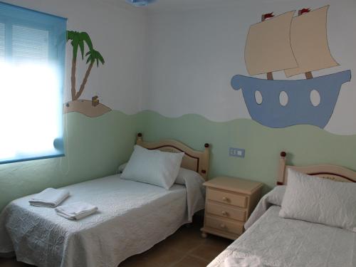 埃爾博斯克的住宿－ÁTICO CAHI，卧室配有两张床,墙上有一条船