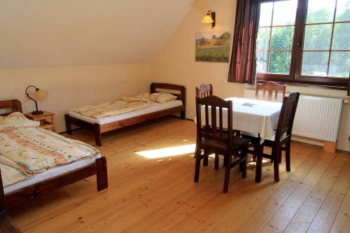 a room with two beds and a table and chairs at Siwejka - Ropki - Beskid Niski in Ropki