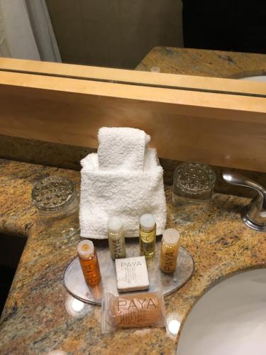 - un comptoir de salle de bains avec un lavabo et un tas de serviettes dans l'établissement Whistler Village Inn & Suites, à Whistler
