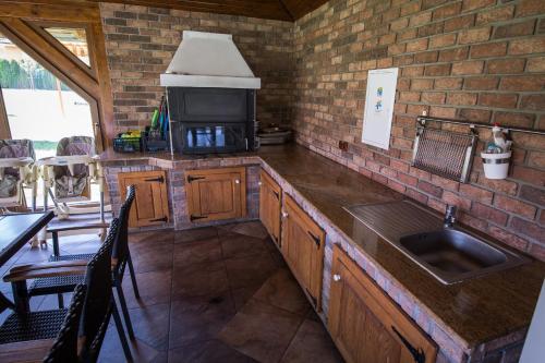 a kitchen with a counter with a sink and a microwave at Villa Gracia Podhájska in Podhájska