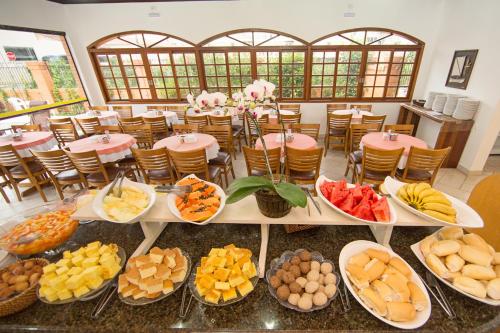 a table filled with lots of different types of food at Elite Hotel in Florianópolis
