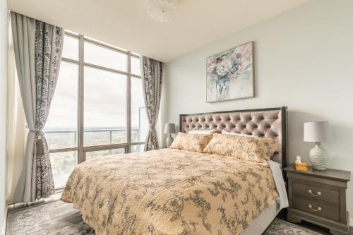 a bedroom with a bed and a large window at Unbelievable Penthouse View with 3 bedrooms in Toronto
