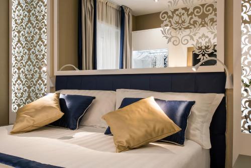 um quarto com uma cama branca com almofadas azuis e douradas em Residenza Venti Settembre em Roma