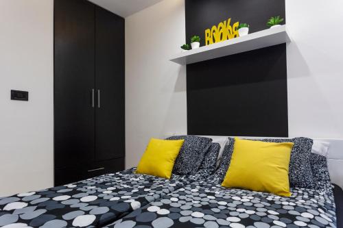 a bedroom with a black and white bed with yellow pillows at Park Apartment in Novi Sad