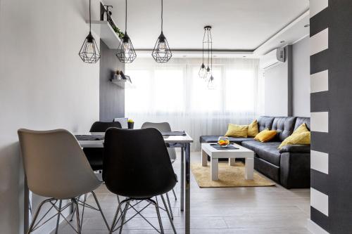 un soggiorno con tavolo, sedie e divano di Park Apartment a Novi Sad