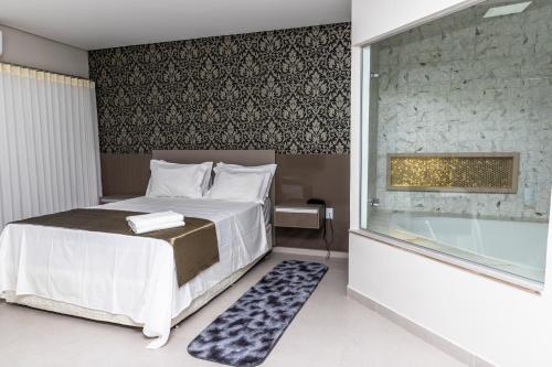 a bedroom with a bed and a bath tub at Vila Real Hotel in Porto Nacional