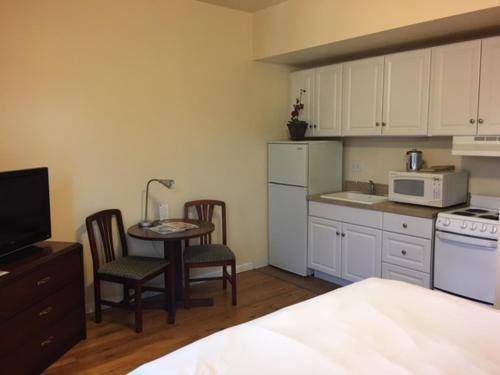 a kitchen with a table and chairs and a microwave at Washington Plaza - Portland in Portland