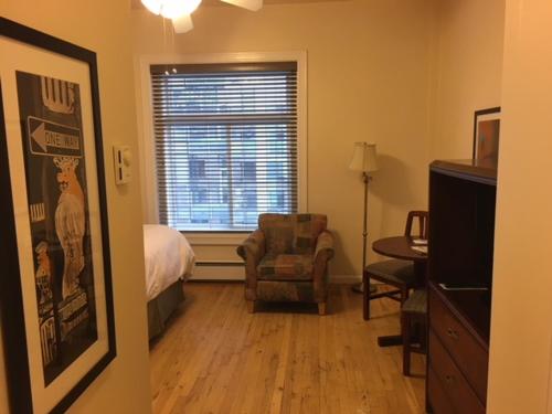 a bedroom with a bed and a chair and a window at Washington Plaza - Portland in Portland
