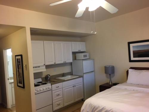 a kitchen with white cabinets and a bed in a room at Washington Plaza - Portland in Portland