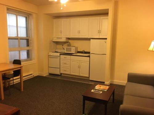 a small kitchen with white appliances and a table at Washington Plaza - Portland in Portland