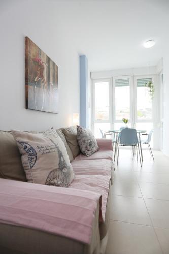 een woonkamer met een bank en een tafel bij Apartamento Playa Las Canteras in Las Palmas de Gran Canaria
