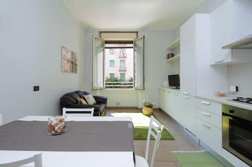 una cucina e un soggiorno con un tavolo e un divano di Spacious and new apt in Città Studi a Milano