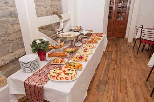 a long table with plates of food and a cake at Vila Camelia in Sinaia