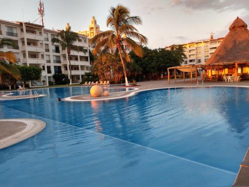 a large swimming pool with a ball in the middle at Apartamento Pelicanos, Nuevo Vallarta in Nuevo Vallarta