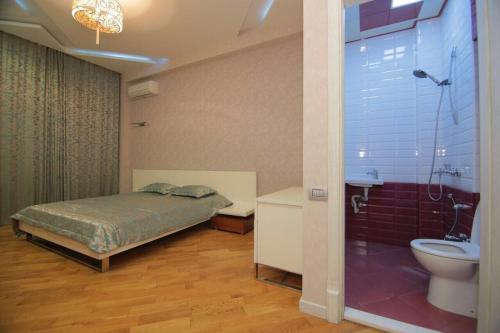 um quarto com uma cama, um chuveiro e um WC em CENTR BAKU. 4 Bedrooms. em Baku