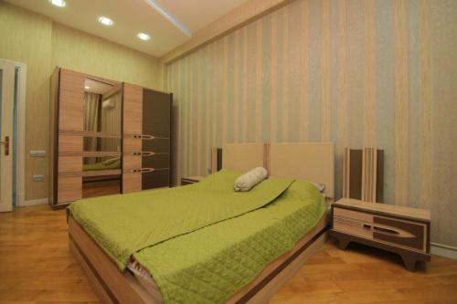 um quarto com uma cama com um cobertor verde em CENTR BAKU. 4 Bedrooms. em Baku