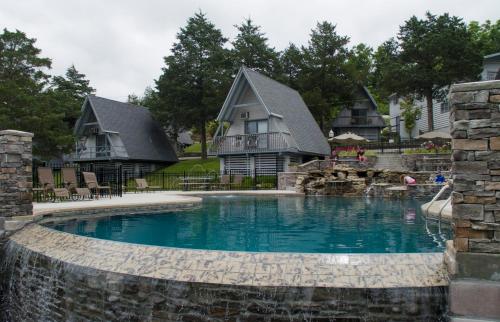 a home with a swimming pool in front of a house at Alpine Lodge Resort in Branson