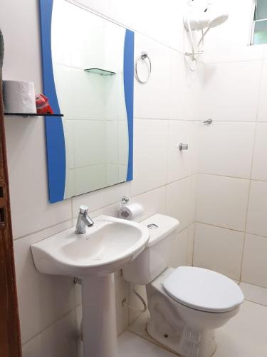 a bathroom with a sink and a toilet and a mirror at Pousada Amazônia in Rio Branco