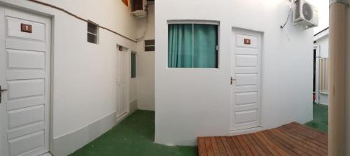 a hallway with two white garage doors and a wooden floor at Pousada Amazônia in Rio Branco