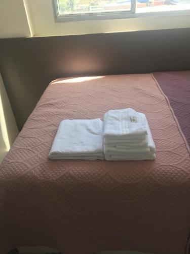 a pair of towels are sitting on a bed at Apartamento Emaús in Parnamirim
