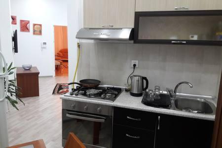 uma cozinha com uma placa de fogão e um lavatório em Bank Respublika Apartment em Baku