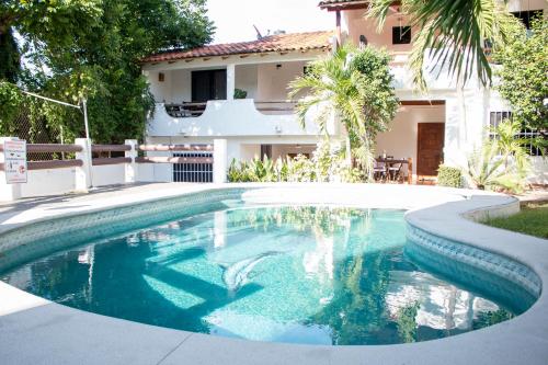 a swimming pool in front of a house at Villa Lupita in Zihuatanejo