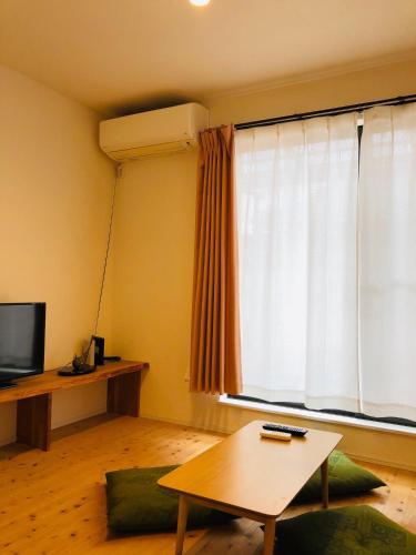 a living room with a table and a large window at Ichijo Premium in Kyoto