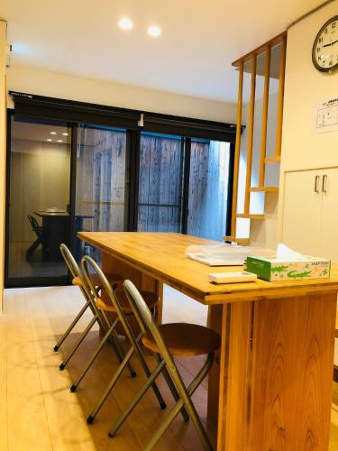 a kitchen with a wooden table and chairs at Ichijo Premium in Kyoto
