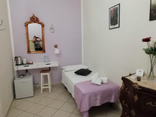 - une petite chambre avec un lit et un miroir dans l'établissement B&B TORRE DEI SARACENI, à Marina di Gioiosa Ionica
