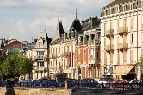 a row of buildings next to a river with cars at Novotel Belfort Centre Atria in Belfort