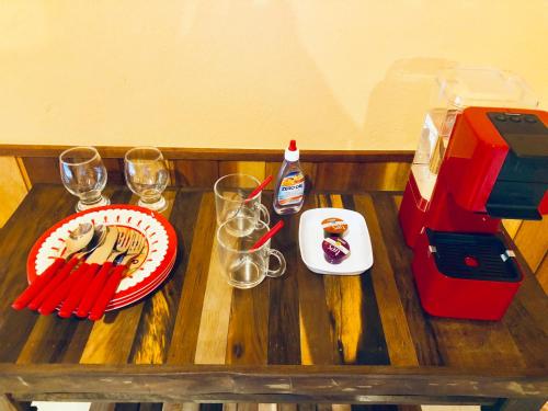 a wooden table with a cake and glasses on it at Pousada Magia da Montanha in Visconde De Maua