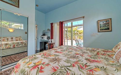 a bedroom with a bed with a floral bedspread at Hale paradise in Keaau