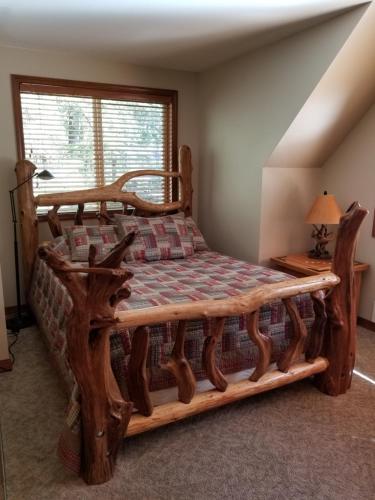 a bed with a wooden frame in a room at Cozy Studio Apartment in Greenwater