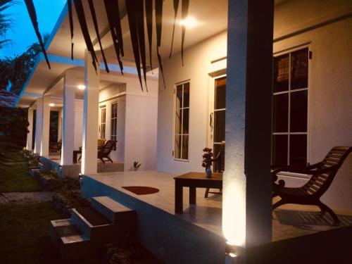 a porch of a house with a table and chairs at La Perla Bentota in Bentota
