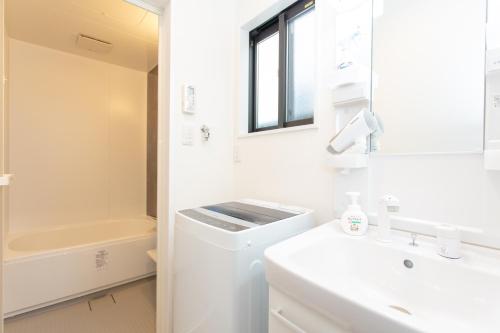 un bagno bianco con lavandino e WC di Tourisakuraann 1goukann a Kyoto