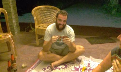 a man sitting on the floor holding a glass at Marari Bethsaida Homestay in Shertallai