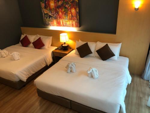 two beds in a hotel room with stuffed animals on them at Le Naview @Prasingh in Chiang Mai