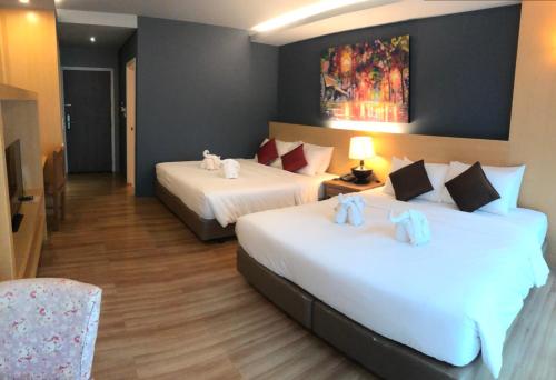 a hotel room with two beds and a television at Le Naview @Prasingh in Chiang Mai