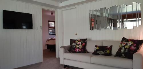 a living room with a couch and a flat screen tv at Sequoia Steps in New Plymouth