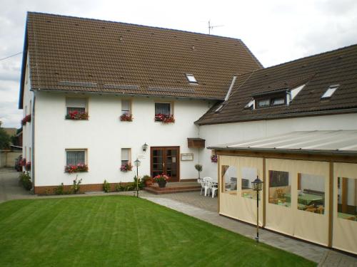 a large white house with a large yard at Hotel-Pension Märkischheide in Vetschau