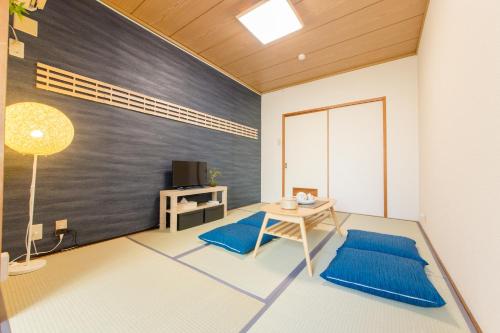 a living room with a table and a tv at Vacational Rental Sunny Heights in Kanazawa