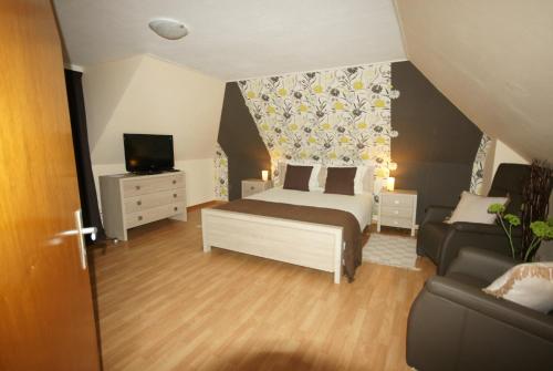 a bedroom with a bed and a tv and a couch at Landgasthof Em Lade in Dahlem