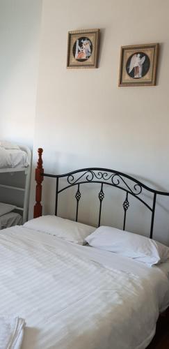 a bed in a bedroom with two pictures on the wall at The Eastern Hotel Accommodation in Ballarat