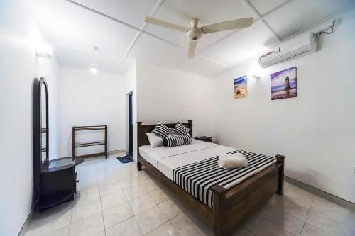 a bedroom with a bed and a ceiling fan at Cloud Inn Kandy in Kandy