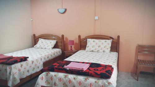 a bedroom with two beds and a table at Fleurvilla in Pereybere